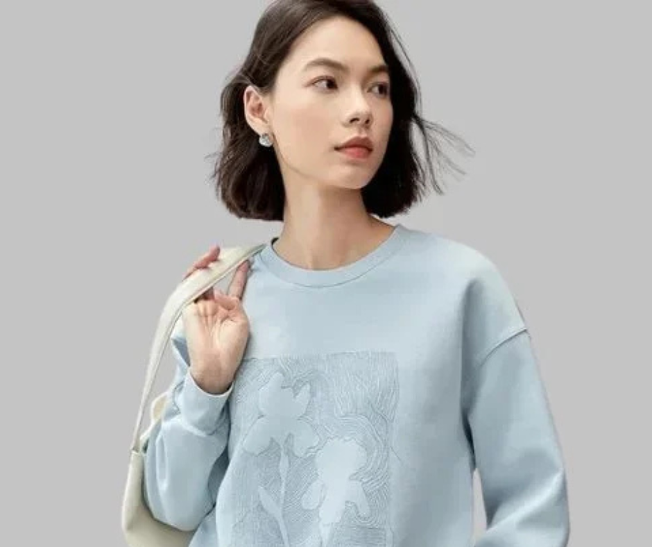 Woman with bob haircut wearing a collared shirt and a gold necklace for a balanced outfit look.