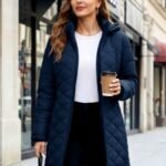 Womens puffer jacket in navy blue with hood, worn as a long winter coat