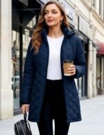 Womens puffer jacket in navy blue with hood, worn as a long winter coat