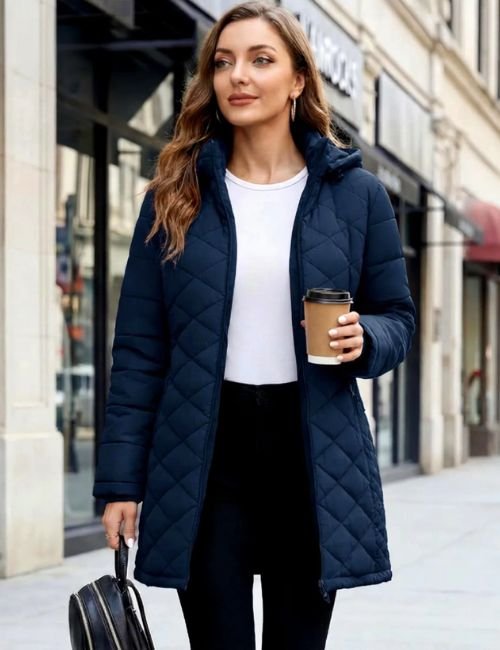 Womens puffer jacket in navy blue with hood, worn as a long winter coat